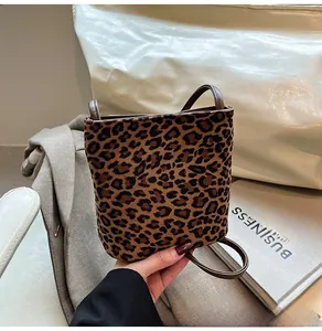 Détail d'un petit sac carré à imprimé léopard avec texture pelucheuse et fine bandoulière brune