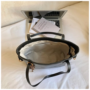 Top view of large black tote bag showing spacious interior with books and a laptop
