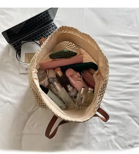 Top view of large straw tote bag showing spacious interior with laptop and daily essentials