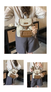 Detail of vintage canvas backpack with faux leather trim and plush bear keychain