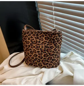 Détail du sac seau à imprimé léopard avec bandoulière marron sous lumière naturelle