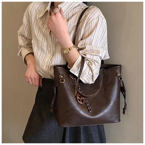 Detail of vintage coffee brown large capacity tote bag with drawstring closure and charms