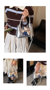 Detailed views of a metallic silver semi-circle handbag with a cute teddy bear pendant
