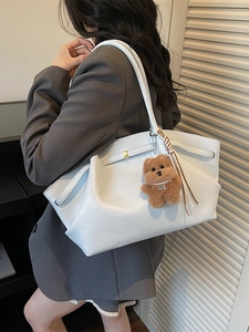 Minimalist beige oversized tote bag with pleated leather texture and plush bear charm