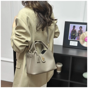 Litchi pattern bucket bag with twist lock in khaki gray shown on model from side back view