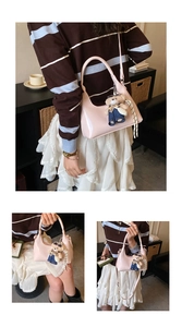 Detail of light pink patent leather crescent bag with cute teddy bear charm accessory