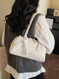 Sac à bandoulière blanc en cuir litchi avec nœud en dentelle en décor d'intérieur