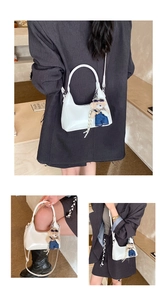 White glossy leather hobo bag with a cute teddy bear charm and adjustable shoulder strap