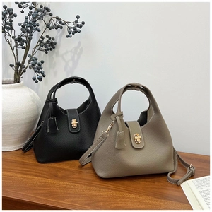 Detail of bucket bags in black and elephant gray leather with gold turn-lock closure