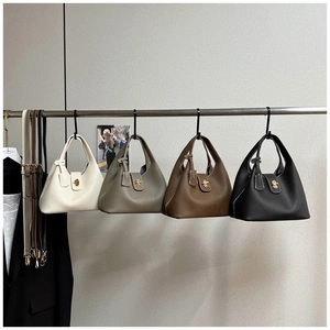 Detail view of four vintage leather bucket bags in white, grey, brown, and black colors