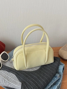 Retro cream Boston handbag in textured PU leather on casual clothing background