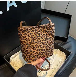 Gros plan du sac seau imprimé léopard avec anse en cuir marron et texture douce