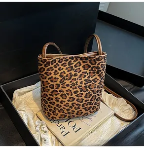 Détail du sac seau imprimé léopard avec anses en cuir sur doublure en soie élégante