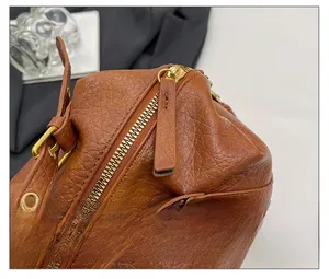 Detail of vintage brown pebble leather texture with smooth gold zipper and hardware