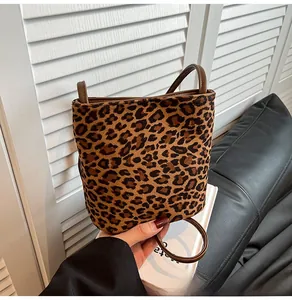 Détail d'un sac seau léopard avec texture en daim et poignée en cuir marron élégante
