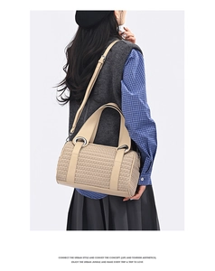 Detail of beige woven pillow bag featuring silver ring hardware and detachable strap