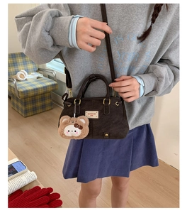 Detail of dark brown matte leather crossbody bag with cute plush bear charm