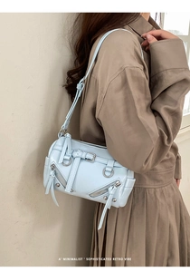 Detail of light blue glossy leather shoulder bag with industrial metallic hardware