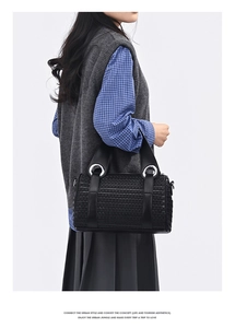 Detail of black woven leather pillow bag with cylindrical body and metal ring hardware