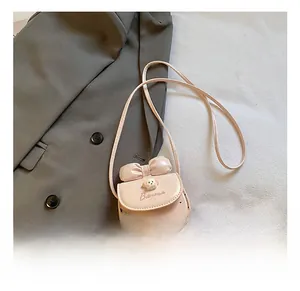 Détail du sac rose pour enfant avec nœud, décor d'ours et motifs de cœurs