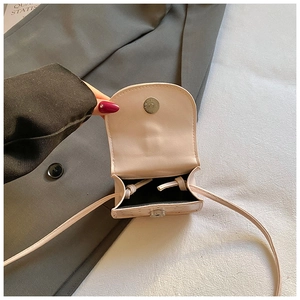 Détail de la fermeture magnétique et de la doublure sur un mini sac à bandoulière rose