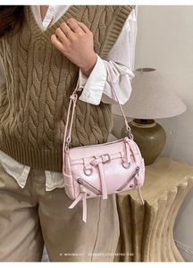 Detail of pink glossy leather tote with rivets and silver zippers in a retro motor style