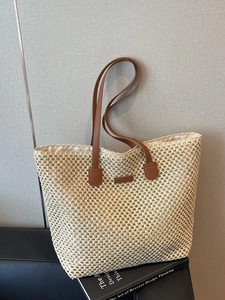 Fashionable straw tote bag with brown leather handles for summer beach and travel
