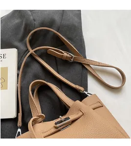 Gros plan d'un sac seau en cuir litchi kaki avec fermoir rotatif argenté