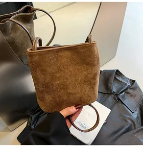 Détail du sac seau mat marron caramel avec anse demi-lune et texture en daim