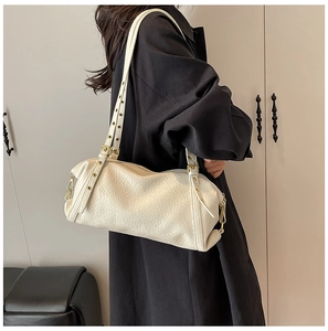 Detail of cream white textured leather shoulder bag with polished gold adjustable strap buckles