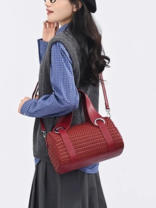 Red woven cylinder boston bag with silver ring hardware and detachable crossbody strap