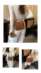 Detail view of brown faux leather crossbody bag with top handle and square flap design