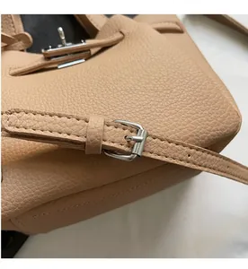 Détail macro d'un sac en cuir grainé avec fermoir rotatif argenté et coutures de précision