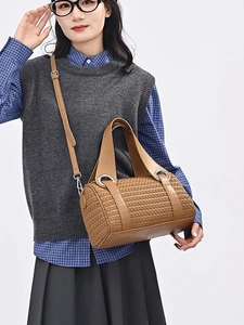 Brown woven leather pillow bag for women featuring large silver ring buckle and strap