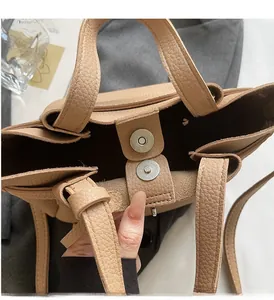 Détail du fermoir magnétique sur un sac seau en cuir kaki avec texture grainée chic