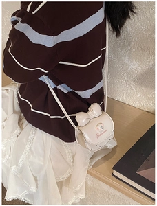 Détail du sac bandoulière blanc en similicuir avec nœud et broderie chiot de dessin animé