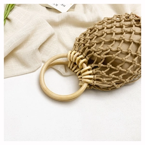 Macro view of a beige hand-woven net bag featuring smooth natural wood circular handles
