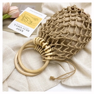 Macro shot of woven mesh bag with wooden handles and drawstring cotton inner pouch