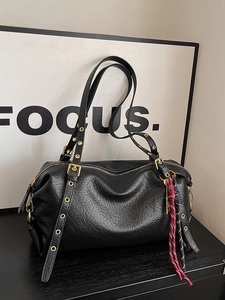 Minimalist black leather underarm bag with metal buckles and colorful braided charm