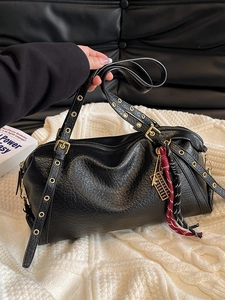 Minimalist black vintage shoulder bag with textured leather and golden metallic eyelets