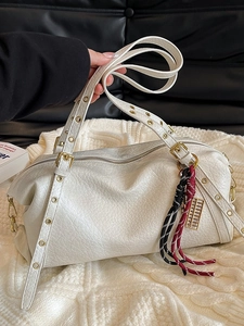 White textured leather shoulder bag with cylinder shape and decorative gold charm