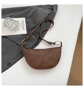 Vue détaillée du sac demi-lune marron avec texture mate rétro et anneaux en métal