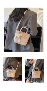 Detail showing litchi texture beige bucket bag with pearl heart and lace bow accent