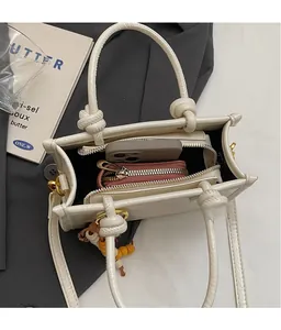 Top view of cream bucket bag showing interior space with zipper and beaded charm