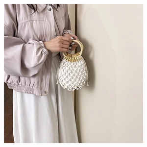Détail du sac en paille tissé à la main avec poignée ronde en bois et doublure à cordon