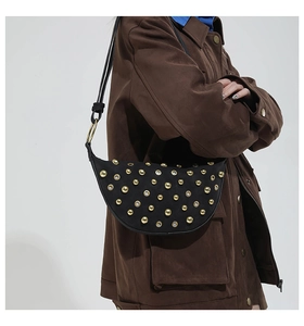 Détails du sac demi-lune noir avec des rivets dorés sur une matière en daim doux