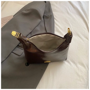 Detailed interior of dark brown leather shoulder bag with gold hardware and light lining