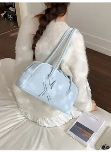 Chic light blue shoulder bag with star charm styled with white knitwear outfit