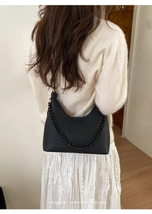 Detail der schwarzen Hobo-Tasche mit Lychee-Muster und dicker Kette an der Schulter