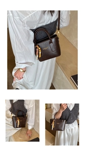 Detail view of coffee brown faux leather tote with bohemian bead pendant and strap